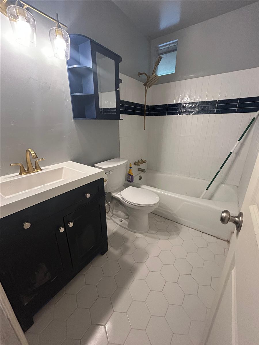Finished bathroom with new drywall, tile, and fixtures