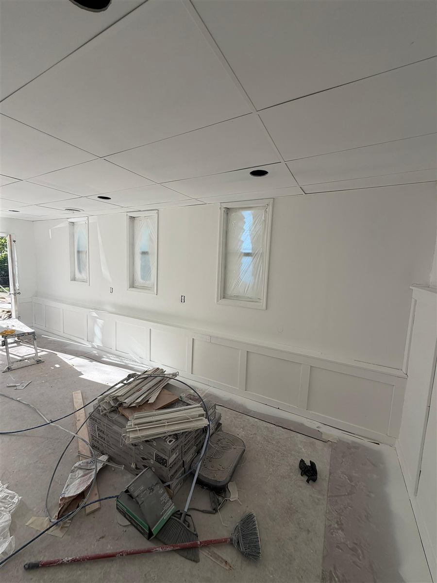 Commercial drywall with wainscoting panels and drop ceiling